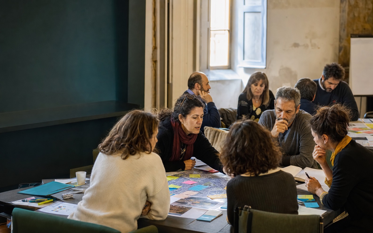 Il gruppo di lavoro attorno al tavolo: mappe, post-it e confronto durante un laboratorio di coprogettazione