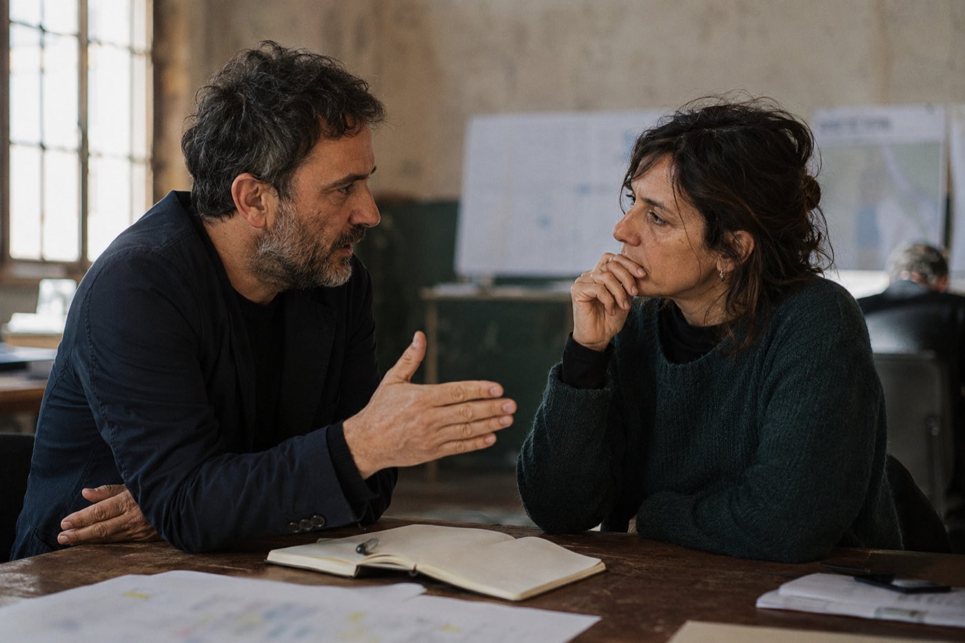 Due persone in conversazione ravvicinata su un quaderno aperto
