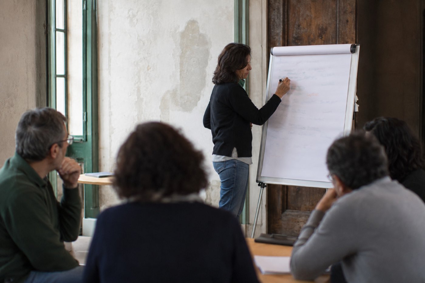 Una persona scrive al cavalletto mentre il gruppo discute in semicerchio