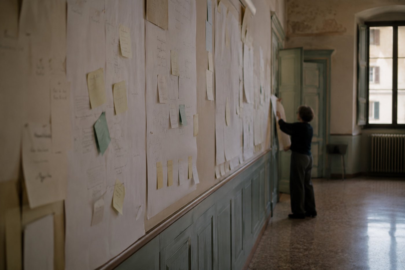 La parete a fine giornata, coperta di cartelloni e appunti