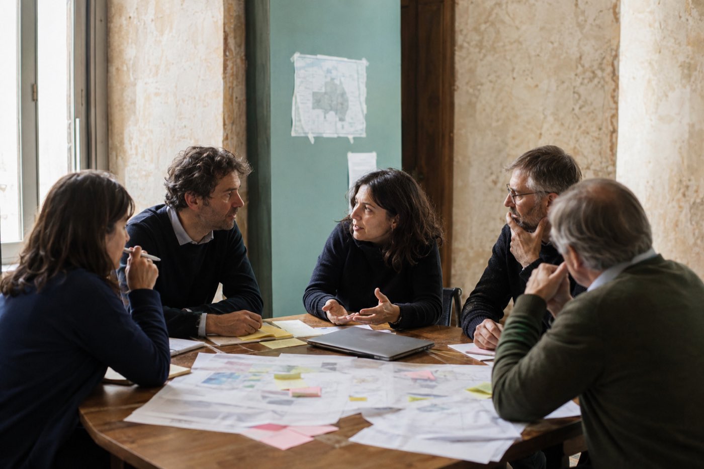 Gruppo al lavoro attorno a un tavolo con il computer chiuso da parte
