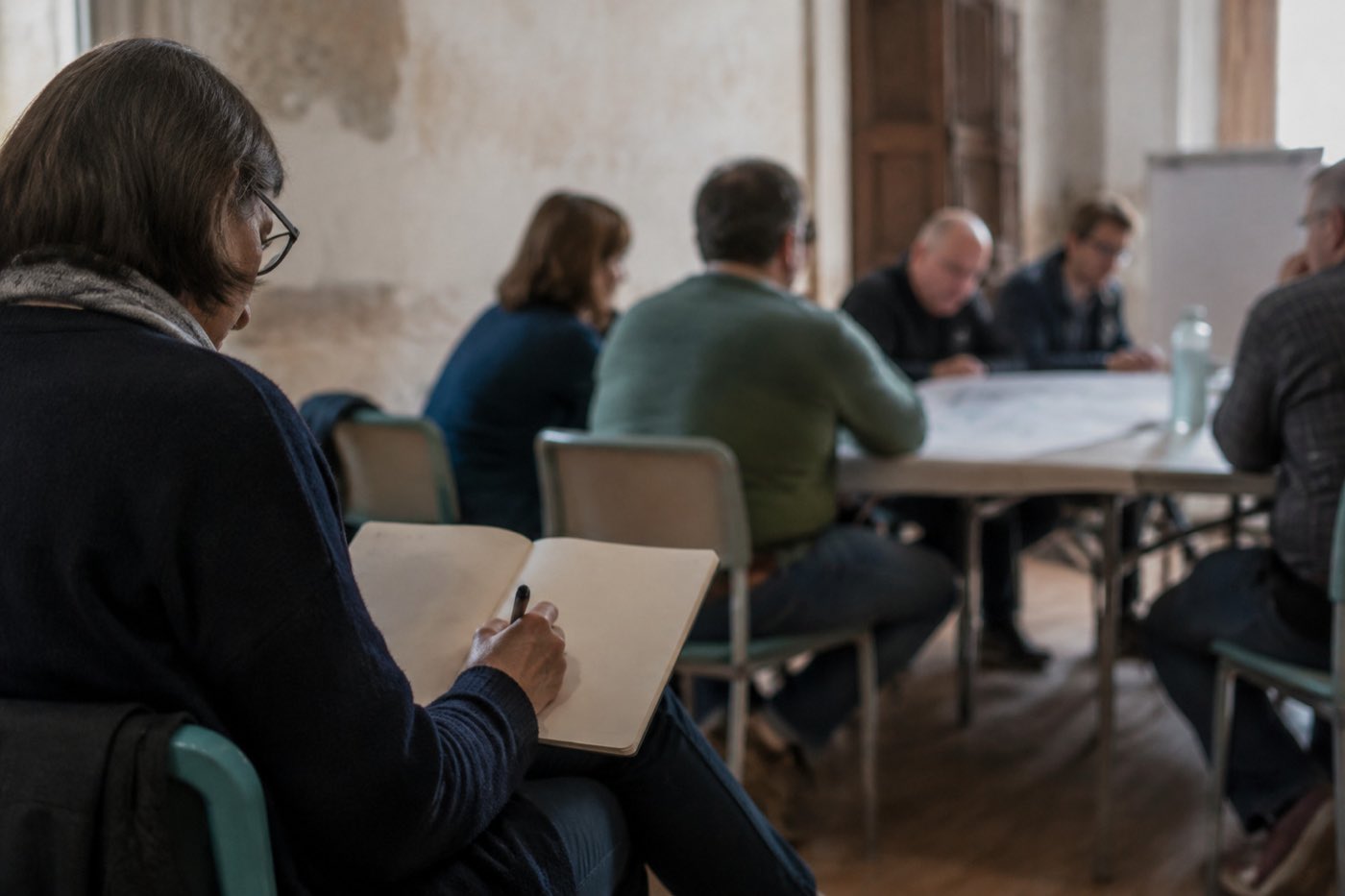 Una persona prende appunti a mano durante un incontro